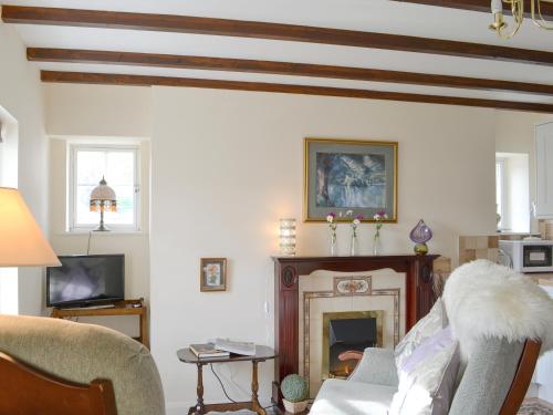 a living room with a couch and a fireplace at Temple House West in Drumnadrochit