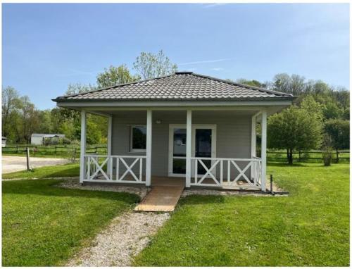 a small house with a porch in the grass at Domaine Saône-Valley in Traves
