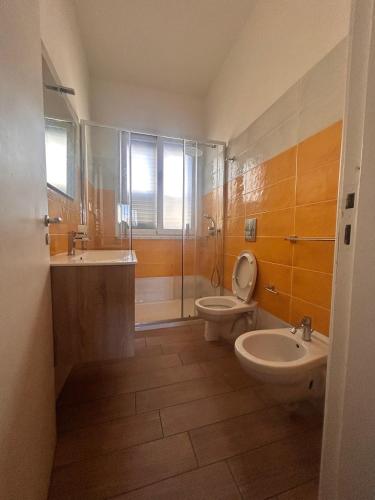 a bathroom with a toilet and a sink and a shower at Pearl Apartment - Baia Verde in Baia Verde