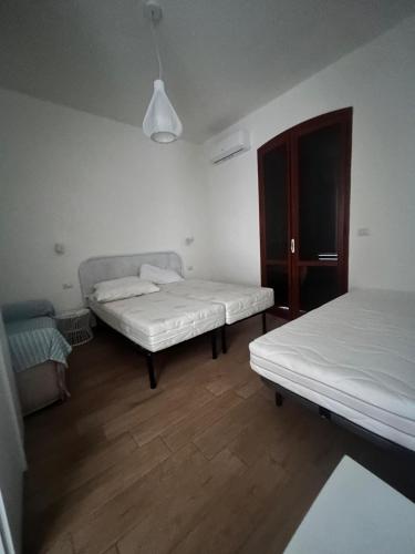 a room with two beds and a cabinet at Pearl Apartment - Baia Verde in Baia Verde