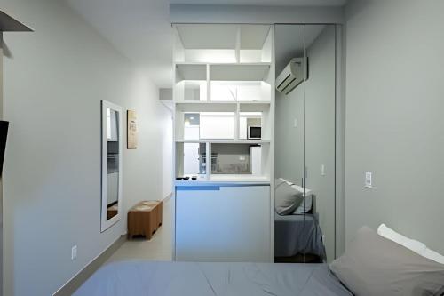 a kitchen with white walls and a white refrigerator at Flat completo e aconchegante - Granja Viana in Cotia