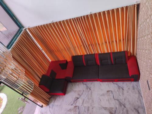 a red and black couch sitting in a room at Inara By BR Homes in Trivandrum