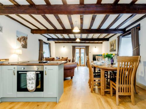 a kitchen and dining room with a stove and a table at The Old Granary - Uk12135 in Hewelsfield
