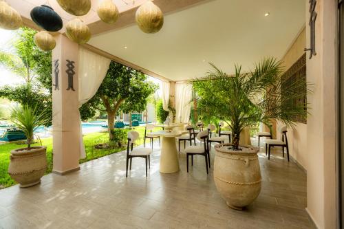 a restaurant with a table and chairs and plants at Villa Stevana in Oulad Mazoug