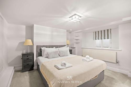 Un dormitorio blanco con una cama grande con toallas. en New! Modern 4BR Home in Windsor City Centre - Sleeps 6 - Office & Garden, en Windsor