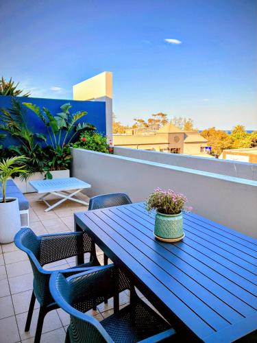a blue picnic table and chairs on a balcony at Palm Terrace Kiama in Kiama