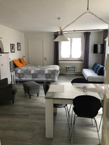a living room with a bed and a table at Joli appartement une pièce avec place de parc in Domdidier