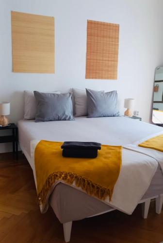 a large white bed with a yellow blanket on it at B&B Baš Baštica in Kladovo