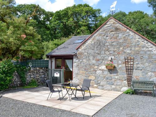 a stone cottage with a table and chairs in front of it at Wee Cordorcan - Uk5890 in Bargrennan