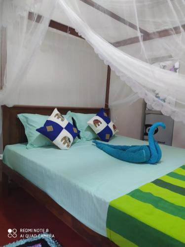 a bedroom with a bed with a blue toy on it at Rosy guest house. in Mirissa