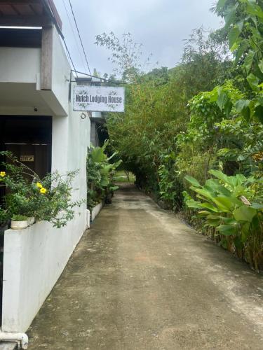 a dirt road next to a building with a sign on it at Hutch Lodging House in El Nido