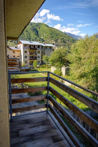 a balcony with a view of a building and a mountain at Mestia Roots in Mestia