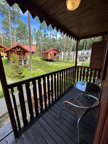 a wooden porch with a table and a chair on it at Perła in Stegna