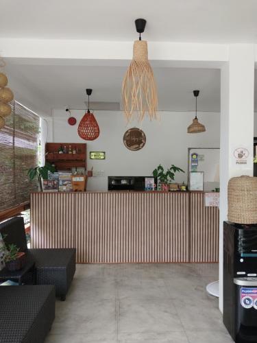 a restaurant with a wooden counter and pendant lights at Hutch Lodging House in El Nido