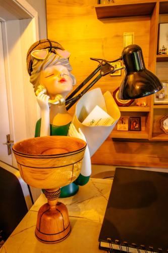 a statue of a woman on a table next to a lamp at Mestia Roots in Mestia