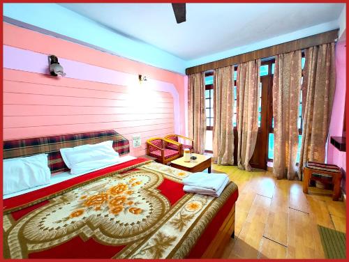 ナイニタールにあるHotel R - Radha - Continental -Mall Road Nainital - Near Naini Lake with Restaurant - Wifi - with Excellent Hospitality - A Luxury Room With Newly Decorated and Renovated Room- Book Nowのピンクの壁の大きなベッドのある寝室