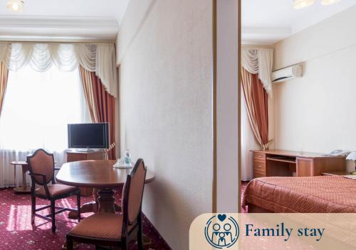 a hotel room with a bedroom with a table and a bed at Ukraine Hotel in Kyiv