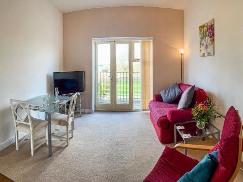 a living room with a red couch and a glass table at Chaplin in Legbourne
