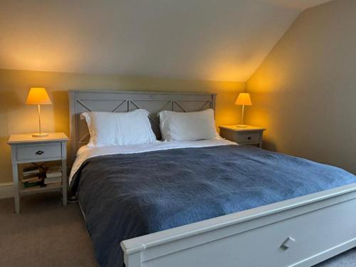 a bedroom with a large bed with two lamps on both sides at Your perfect Winter stay, private parking for up to 3 cars, EV Charging Point, Tennis Court, Large Garden area & Lots of nearby things to do! in Goodnestone