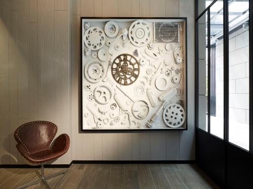 a framed picture of plates on a wall next to a chair at Tango Inn Taipei Jihe in Taipei
