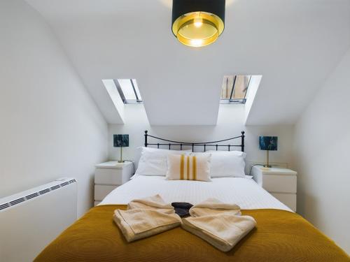 チェルトナムにあるArcadia House, central location with parking, King sized beds and WiFiのベッドとタオル2枚のある寝室