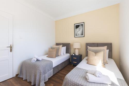two beds in a small room with white walls at Élégant appartement 3 pièces à Hydra in Hydra