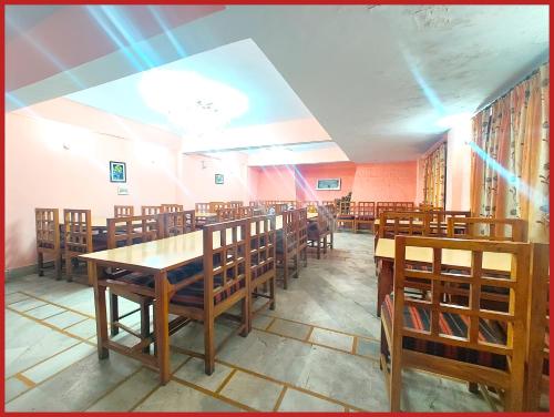 ナイニタールにあるHotel R - Radha - Continental -Mall Road Nainital - Near Naini Lake with Restaurant - Wifi - with Excellent Hospitality - A Luxury Room With Newly Decorated and Renovated Room- Book Nowの木製のテーブルと椅子のあるダイニングルーム