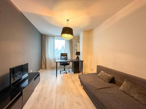 a living room with a couch and a desk at Simcity 3 I Skyline Elegance I 3BR, private parking, sunny terrace with panoramic city view 5min walk to city square in Banská Bystrica