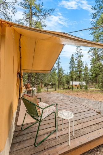a chair and a table on a wooden deck at Highland Grand Canyon Glamping in Grand Canyon Village