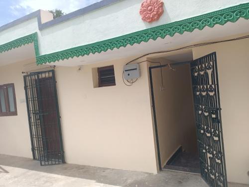 a white building with an open door and a gate at LAkSHMI HOMESTAY in Tirupati