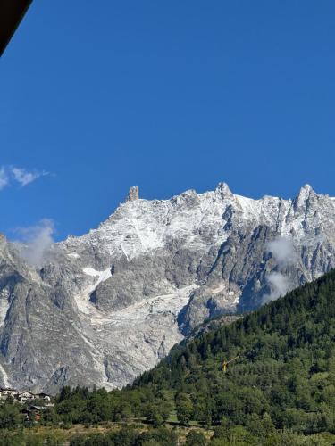 a mountain with a tower on top of it at Nido Alpino - Vista Montagne e Relax Terme a 150m in Pré-Saint-Didier