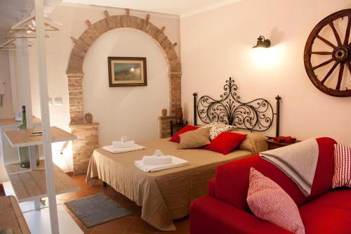 a bedroom with a large bed and a red couch at SicilyStudio Apartment in Taormina-Murmuria Minerva in Taormina