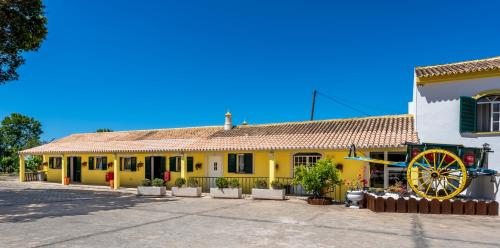 a yellow building with a yellow wagon in front of it at Quinta do Moinho in Loulé