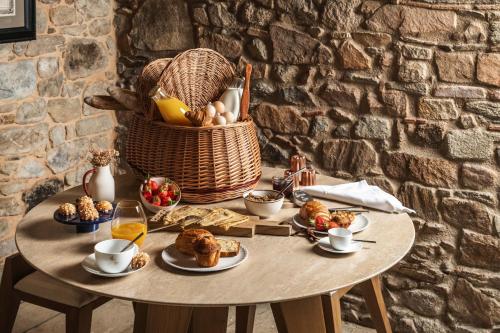 a table with food and a basket of food at Domaine des Etangs, Auberge Collection in Massignac