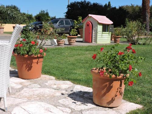 two large pots of flowers in a yard with a red phone booth at Casale Fedele Relax B&B Vicino al Borgo in Ronciglione