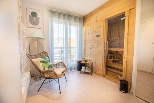 a living room with a chair and a window at Appartement 3ch rénové en 2023 avec sauna in Gérardmer