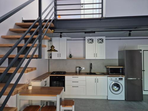 a kitchen with white cabinets and a staircase at Exclusive Apartments "Lviv Vernygory 14", Modern Apartments with Self Check-in in Lviv