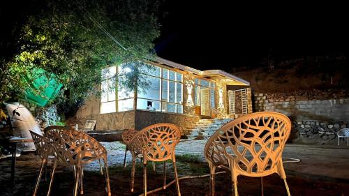 a group of chairs sitting in front of a house at BULAN CHALETs in Astor