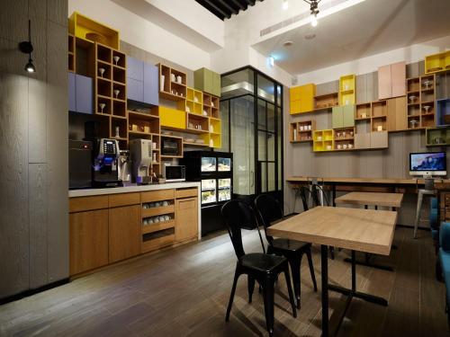a kitchen with a wooden table and chairs in a room at Tango Inn Taipei Jihe in Taipei
