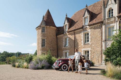 a man and two children standing in front of a house at Domaine des Etangs, Auberge Collection in Massignac