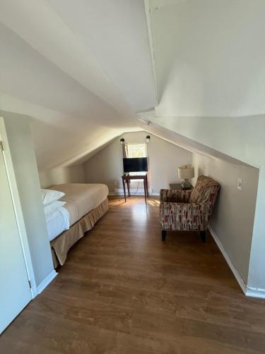 ein Schlafzimmer mit einem Bett, einem Stuhl und einem Klavier in der Unterkunft Elizabeth Loft 1BR Parking Central in St. John's