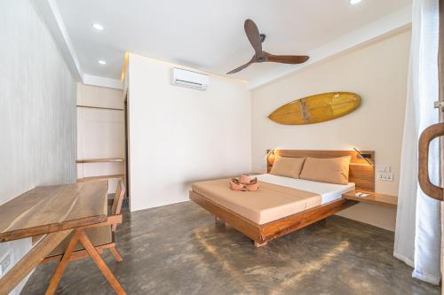 a bedroom with a bed and a wooden table at Sunlit Hostel in General Luna