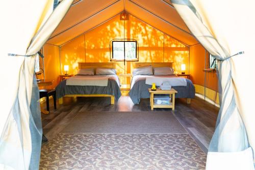 a room with two beds and a table in a tent at Dominion Hill Country Inn in Bocabec