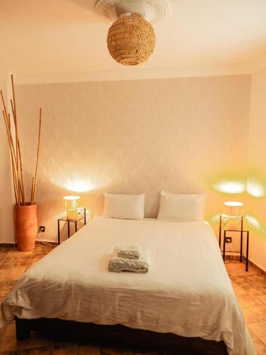 a bedroom with a large white bed with two lamps at Berber Shelter in Tamraght Ouzdar
