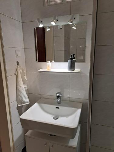 a bathroom with a white sink and a mirror at Sleep - See - Nah in Klagenfurt