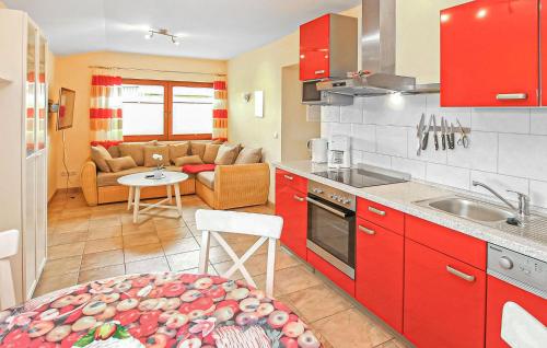 a kitchen with red cabinets and a living room at Ferienwohnung Zislow in Zislow