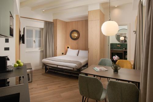 a hotel room with a bed and a table and chairs at Amira Ca' Argento Premium Apartments in Trieste Center in Trieste