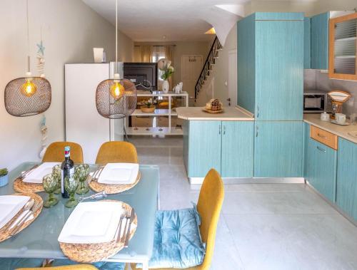 a kitchen with blue cabinets and a table and chairs at LITSA in Iraklitsa
