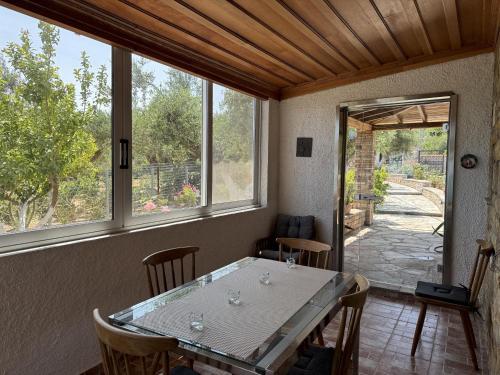 a dining room with a table and some windows at Blue Fox 1 in Chrani