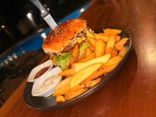 a plate with a sandwich and french fries on a table at Escape Caribeño in Puerto Viejo